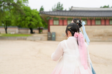 Seoul, June 2025: Two Korean women in their twenties stroll through Gyeongbokgung Palace's halls...