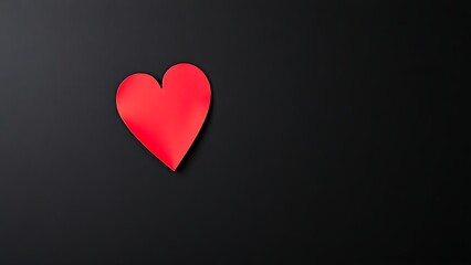 Minimalist red heart on dark textured background with directional lighting