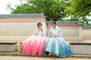 In Seoul in June 2025, two Korean women in their twenties, dressed in charming pink and sky-blue...