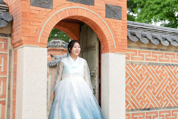 In Seoul in June 2025, two Korean women in their twenties wearing pink and sky-blue hanbok stand in...