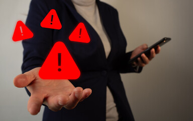 Business person's hand holding a Warning icon and surrounded by other icons, concept of virus alert...