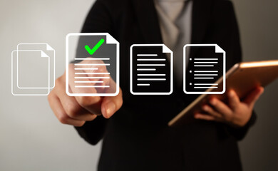 Businesswoman holding a tablet while pointing at a document with a check mark standing out from...