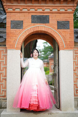 In Seoul in June 2025, two Korean women in their twenties wearing pink and sky-blue hanbok stand in...