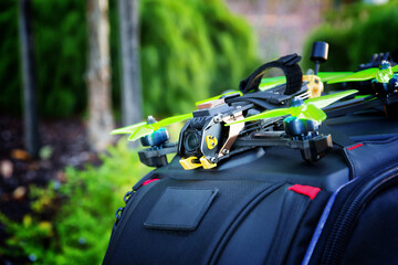First person view drone sitting on a backpack with a garden in the background