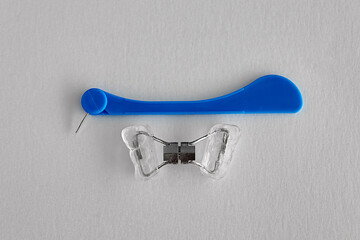 Orthodontic palatal expander and blue adjustment key on white background. Removable dental appliance used to widen the upper jaw in orthodontic treatment. © Tatiana