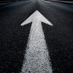 A white arrow painted on a dark asphalt road, guiding the way