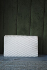Sleep pillow placed on a soft surface against textured wall