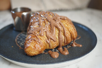 Delicious chocolate croissant served with a sweet drizzle