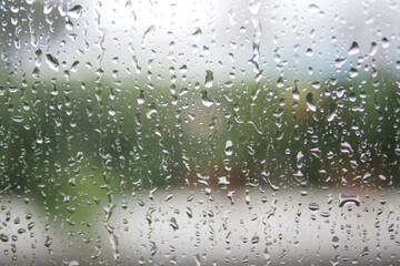 Rain droplets create a serene view on a windowpane