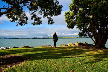 A blonde woman wearing a jacket is enjoying the natural beauty around Whangarei Warf, New Zealand.
