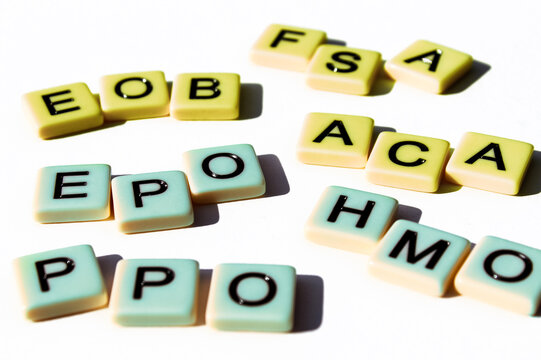 Several health insurance terminology acronyms design element in 3d letter tiles isolated on a white background