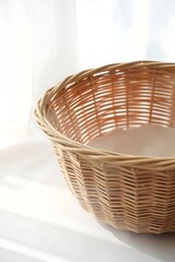 Fototapeta premium Woven basket on white surface basking in the soft glow of daylight