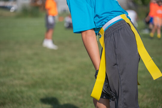 Children participate in flag football practice at a community park in summer under clear skies - Powered by Adobe