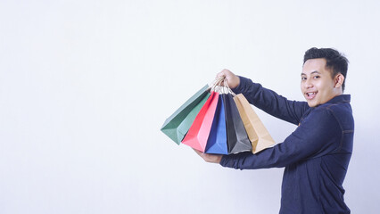 Portrait of happy Asian man holding shopping bags isolated on white background