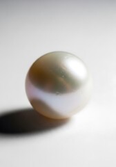 Obraz premium Elegant iridescent pearl against a plain background symbolizing purity and luxury