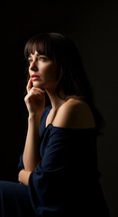 Fototapeta premium Woman in dark dress, thoughtful pose