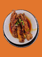 Spicy and aromatic chicken feet, a popular Asian delicacy, served in a white bowl in a steamer.