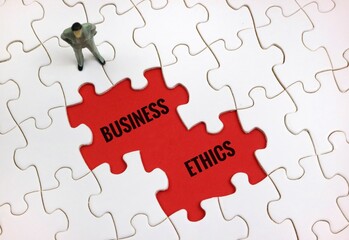 Business Ethics Concept Depicted with Puzzle Pieces and Figurine. with text on a red background
