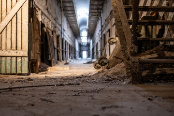 Ground level view of the dirty floor down a cell block at Eastern State Penitentiary historic site.
