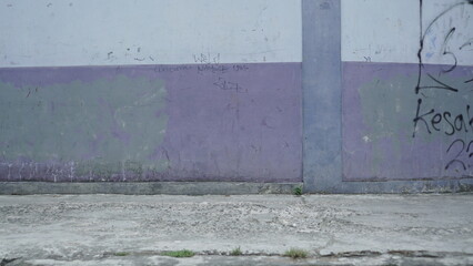 the wall at the edge of the road is full of graffiti