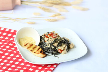 fold fresh squid ink into cooked pasta, coating the noodles with its striking, briny flavors. Served with sautéed calamari, garlic and lemon