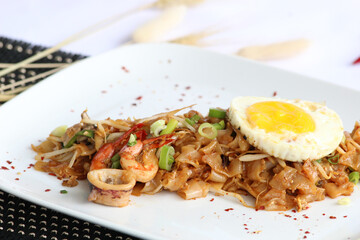 kuey Teow Goreng  or stir-fried flat rice noodles. A popular Southeast Asian dish, especially in Malaysia and Singapore, and is often called Char Kway Teow. 