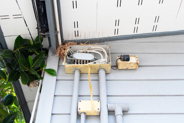 Modern Wi-Fi router for 5G old damaged box small plastic wiring with pipe installed outdoors wall home to provide internet. White wireless technology side mounted signal control. fast wifi transfer.