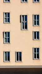 Architectural facade with multiple windows, showcasing building design in warm natural sunlight.