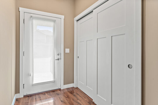 White door with a window in front of a white closet - Powered by Adobe
