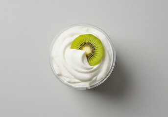 Creamy Dessert Topped with Fresh Kiwi Slice in Transparent Cup on Light Background