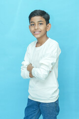 Young indian boy wearing casual white T-shirt and jeans.posing against blue background.Studio shot....
