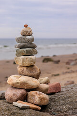 Balance of Nature.

A carefully stacked tower of smooth stones stands against the backdrop of a calm, misty sea. Each stone is unique, yet together they form a cohesive structure – a symbol of harmony