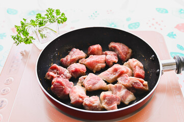 粉をまぶした豚肉を焼いていく
