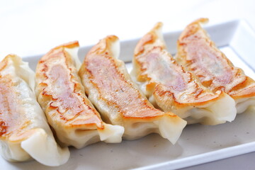 焼き餃子 - 外がパリパリ、中がジューシー、焦げ目がおいしそうな焼きギョウザ
