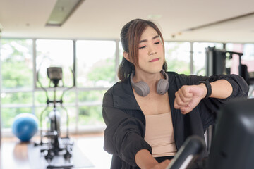 Asian non binary transgender woman in gym training for healthy fitness lifestyle with exercise bike