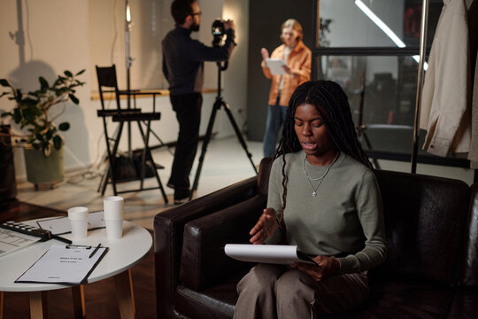 Young Adult Black Woman Reading Script during Acting Audition in Studio Setting