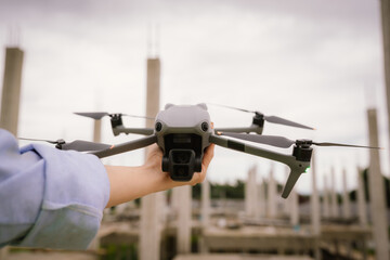 A woman operates a drone using a handheld remote control outdoors, showcasing modern technology, precision navigation, and aerial exploration in a high-tech, futuristic leisure activity.