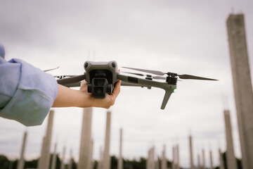 A woman operates a drone using a handheld remote control outdoors, showcasing modern technology, precision navigation, and aerial exploration in a high-tech, futuristic leisure activity.