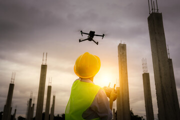 A female construction worker in a safety vest and hard hat operates a drone on-site, using smart technology for surveying, inspection, and monitoring in modern engineering projects.