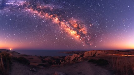 Milky Way's light over rolling hills meets dark ocean under a starry sky