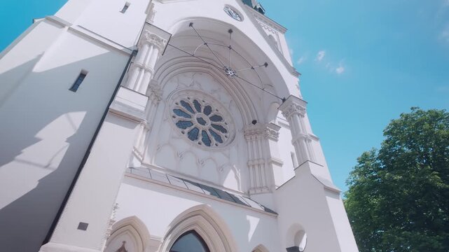 Rose glass window and Neo-Gothic architecture of Catholic parish church