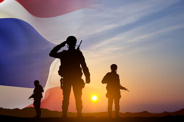 Silhouette of a soldiers with Thailand flag against the sunset