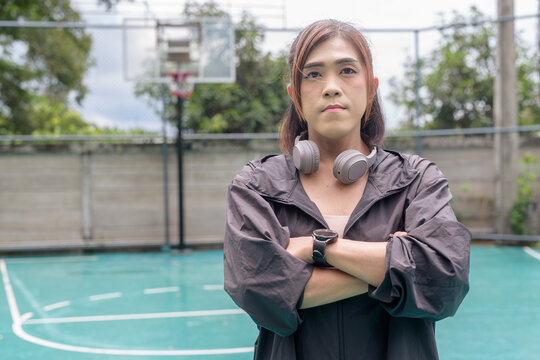 Transgender non binary woman posing confidently on outdoor basketball court