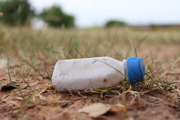 Old plastic bottles left on the ground, grass, old medicine bottles, environmental pollution.