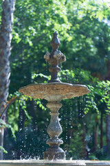 07/22/2025 ronda,malaga,spain Water gracefully cascading from an antique stone fountain, nestled...