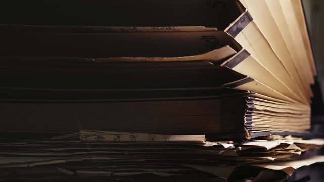 Academic researcher places aged archival documents into worn folders