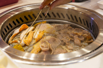 Grilling meal. Korean-style barbecue, where diners grill thinly sliced meat right at the table, flipping pieces as they sear and enjoying them fresh off the grill in a shared
