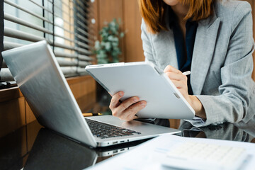 Confident businessman working on laptop, tablet and smartphone at her workplace at office.