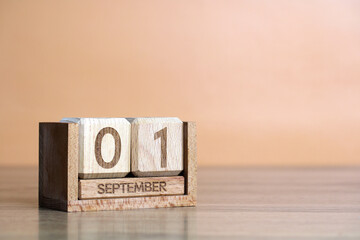Wooden perpetual calendar showing september 1st on orange background