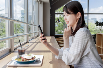 カフェでスマホを使う女性